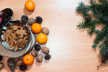 Bird eye view on gingerbreads in a festive box on a wooden table adorned with seasonal accents of...