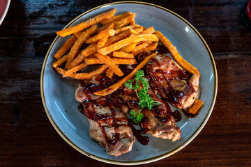freshly chargrilled barbecue chicken thighs served with sweet potato fries.