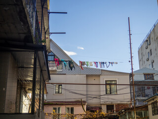 Fototapeta premium Laundry is dried on a long line on the street. Local life in Asia. Batumi balconies and courtyards.