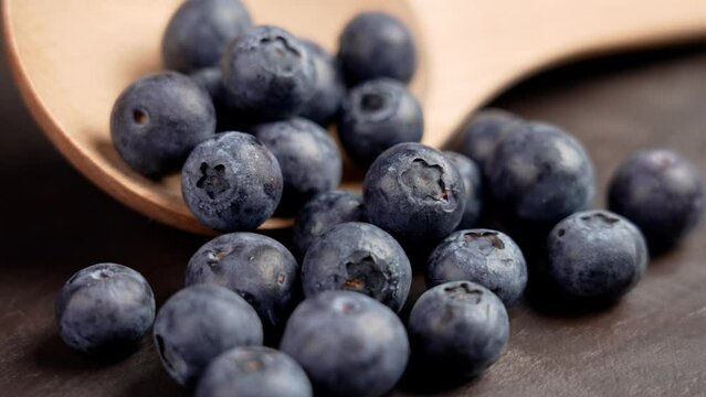 Fresh blueberries and wooden kitchenware close up. Rotation