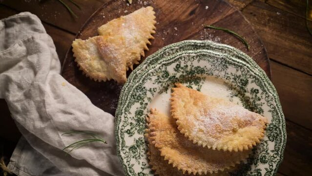 A crescent-shaped pastry whose filling is made of eggs and almonds wrapped in crispy dough, cut in an artisanal way and sprinkled with sugar.