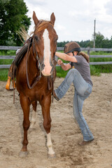A woman climbing on her horse