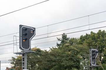 lights at a track crossing,A traffic light with a orange signal is installed in the railway tracks.