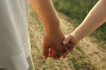 A man holds a woman's hand.