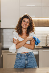 Fototapeta na wymiar A Woman Standing In A Kitchen With A Rag