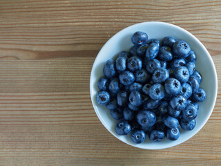 Freshly picked blueberries in a white vintage ceramic bowl. Selective focus, Free text space.