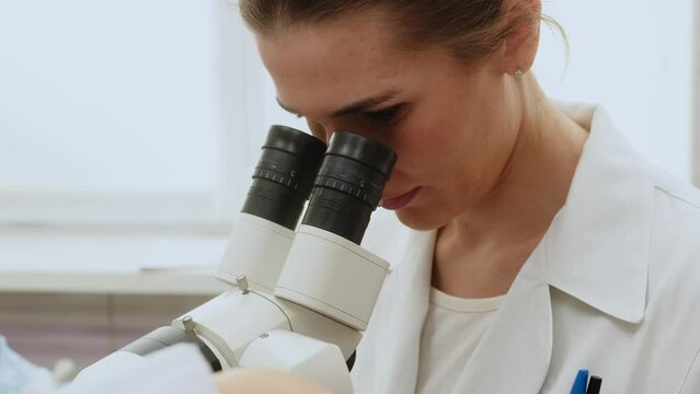 Female Gynecologist examining patient on chair with gynecological equipment. Colposcopy, examination of a cervical cancer. Colposcope close-up. Maternity fertility IVF issues. Abortion and ovulation