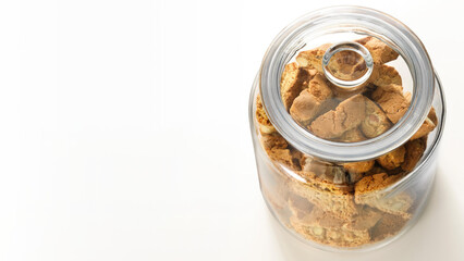 Top view of a glass jar filled with rusks, isolated on white copy-space background.