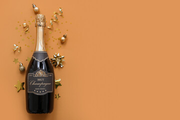 Champagne bottle with Christmas decor on orange background