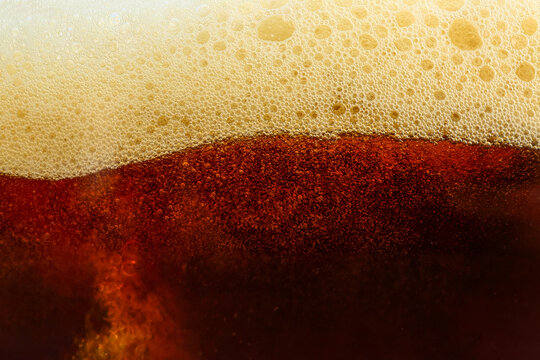 Dark beer with foam as background