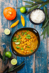 Traditioneller indischer vegetarischer Curry Eintopf mit Süßkartoffeln, Kürbis und Reis serviert als Draufsicht im Kochtopf