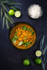 Traditioneller indischer vegetarischer Curry Eintopf mit Süßkartoffeln, Kürbis und Reis serviert als Draufsicht im Kochtopf