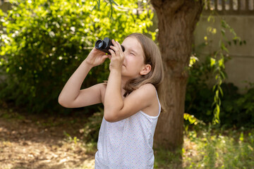 Young school age child, girl looking up into the sky through a magnifying monocular watching birds,...