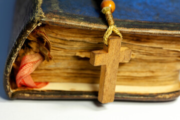 Very old antique prayer book or a Bible and a wooden rosary Christian cross, Christianity and...