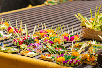 Traditional balinese offerings to gods in Bali with flowers and aromatic sticks.