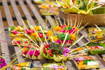 Traditional balinese offerings to gods in Bali with flowers and aromatic sticks.