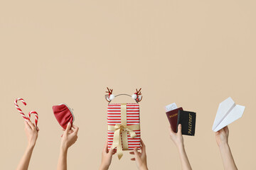 Female hands holding passports with paper plane and gift on light background. New year vacation...