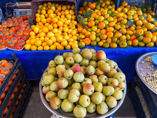 Various fruits at the farmers' market. pear, mandarin, lemon, persimmons.