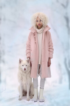 albino African girl in pink furcoat with white husky dog on winter forest background full body photo