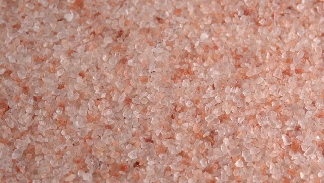 Pink himalayan salt or rock salt rotating close up background side light. Trace minerals salt used for cooking and food presentation, decorative lamps, and spa treatments
