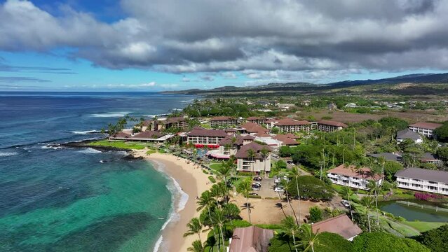 Aerial Kauai Hawaii Poipu Beach beach condominium homes 2.  Surfing swimming tourist Hawaiian seascape recreation. Swimming and snorkeling areas, reef surf. Economy is tourism based. Pacific ocean.