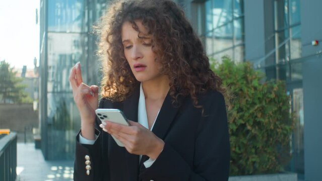 Caucasian young 20s hopeful businesswoman wish hope crossed fingers praying gesture ask god begging wishing luck in city outdoors worried upset business woman mobile phone failure bad result loss fail