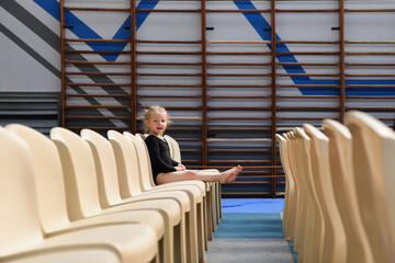 A gymnast girl sitting in the auditorium