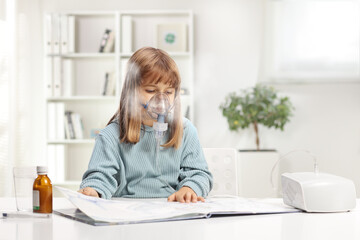 Little girl reading a book and using a nebulizer - obrazy, fototapety, plakaty