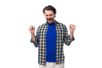 Naklejka premium happy brunette brutal man with a beard in a plaid shirt rejoices in good luck