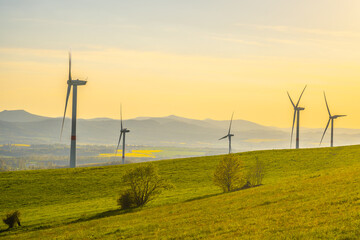 Obraz premium Wind power plant at sunset time. Clean and sustainable energy theme. Aerial drone view.