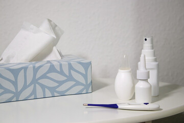 Flue medicine bottles and a thermometer on white table in baby room