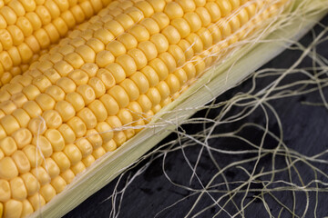 a ripe corn cob covered with water drops