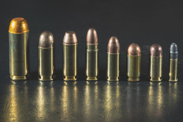 Various pistol cartridges from the weakest 22lr to the most powerful 50AE.  Close-up photo.