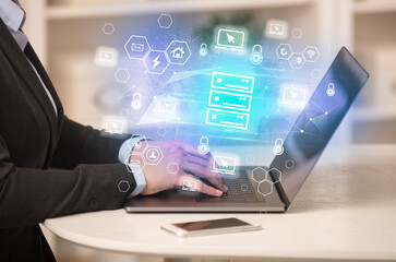 Hands working on laptop with digital icons