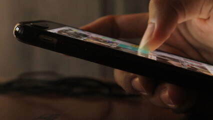 Close-Up Side View of Hand Engaged in Doomscrolling Social Media Feed