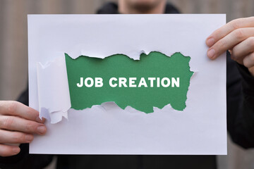 Man holding colorful sheet of paper with inscription: JOB CREATION. Job creation and stability business industry concept. Employment. - obrazy, fototapety, plakaty