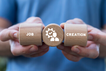 Man holding wooden blocks with icon sees inscription: JOB CREATION. Job creation and stability...