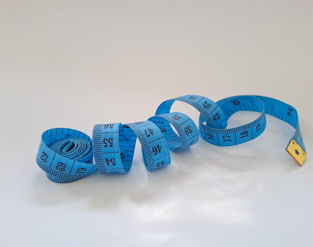Meter tape. Blue measuring tape curls on a white background isolated. Tailor's sewing cloth measuring tool. Ruler for body measuring.