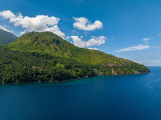 Fototapeta na wymiar Mountain cliff near the coast. Blue sea in Camiguin Island. Philippines.