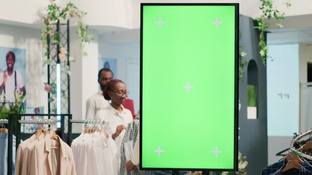 Second hand clothing shop green screen kiosk ready to be used by clients to choose between clothes. Chroma key digital display in thrift shop showcasing available garments sizes