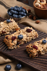 Tasty granola bars with berries on table