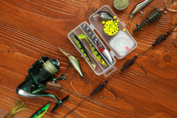Fishing tackle on wooden table, flat lay