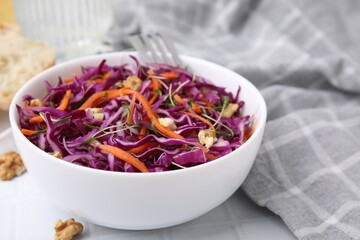 Tasty salad with red cabbage and walnuts on white table, closeup