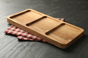 New wooden compartment tray and kitchen towel on dark grey table