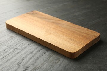 One wooden cutting board on dark grey table