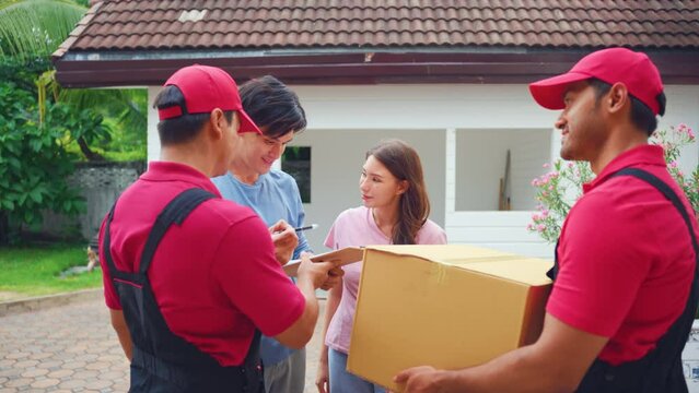 Young delivery man delivering package to couple customer at home.