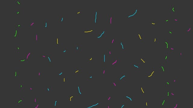 Colored threads or thin ribbons fly up and explode against a dark background.