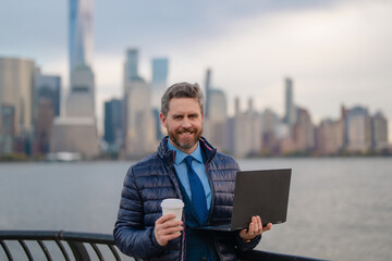 Business man in warm jacket drink coffee in NYC. Businessman in winter New York, Manhattan. Handsome business man outside in winter. Mature man in jacket walking on street drink take away coffee.