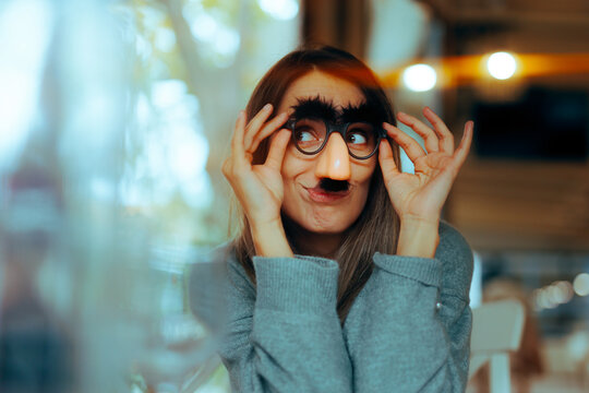 Funny Woman Wearing Silly Mustache Party Accessories Glasses. Girl with a sense of humor using disguise eyeglasses for a prank
