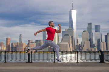 Man runner in sport outfit run in NYC. Motion, healthy run. Mature jogger run near Manhattan downtown. Muscular athlete sportsman run in city. Running sportswear. Handsome guy running workout outdoor.